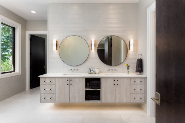 Elegant Bathroom in New Luxury Home with Two Sinks and Circular Mirrors